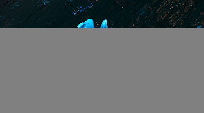 Side view of red and blue Under Armour training shoes.